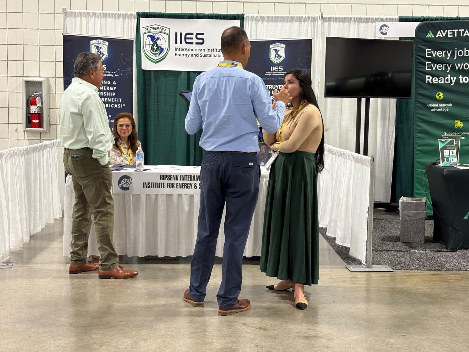 Visitantes conversan con el equipo en el stand de RIPSENV IIES en The Energy Expo